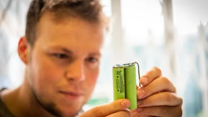 Man holding batteries looking at them