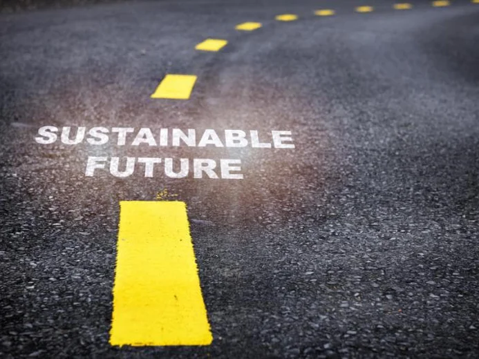 Road with words 'sustainable future' written and then yellow line